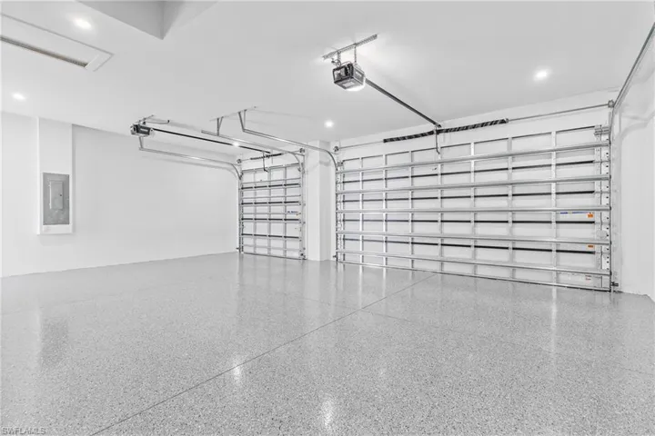 Garage featuring electric panel and a garage door opener