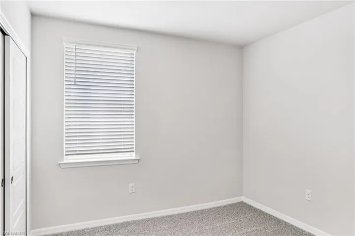 Empty room featuring carpet and baseboards