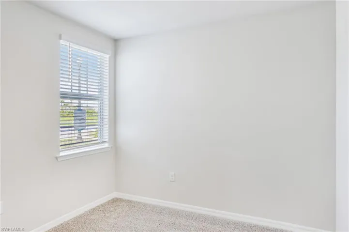 Carpeted empty room with baseboards