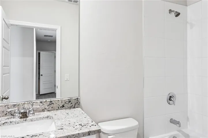 Bathroom featuring vanity, toilet, and shower / tub combination