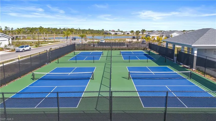 View of tennis court with community basketball court and a water view