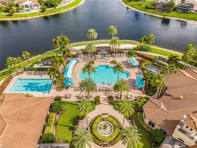 Expansive aquatic facility featuring a resort-style pool with a waterslide, a lap pool, and a large central fountain