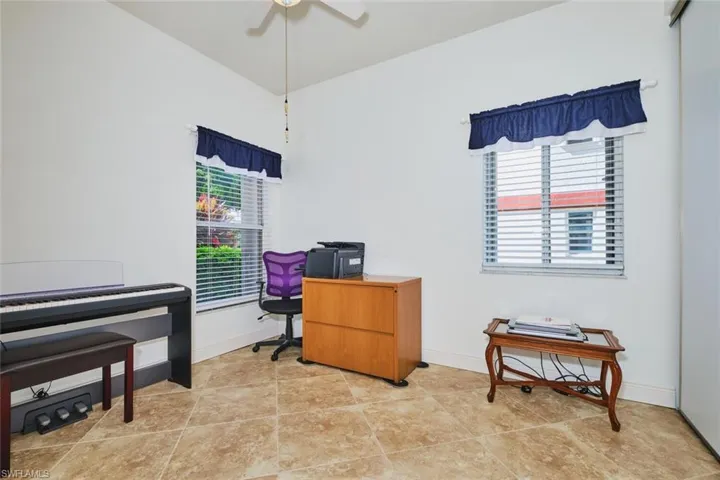 Office area featuring light tile patterned floors and a ceiling fan