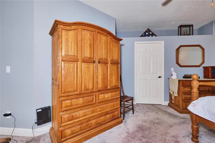 Bedroom featuring light carpet and baseboards