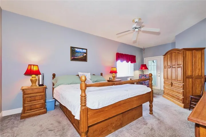 Bedroom with light carpet and a ceiling fan