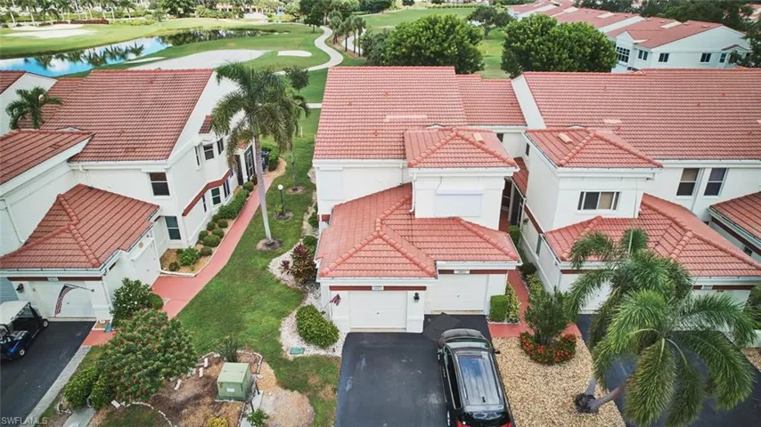 Aerial view of residential area with a nearby body of water and a golf club