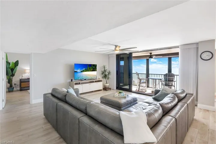 Living room featuring ceiling fan, light wood-type flooring, and floor to ceiling windows