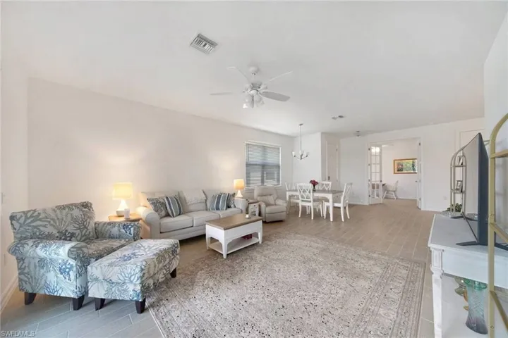 Great room with light plank tile floors and all contents here convey