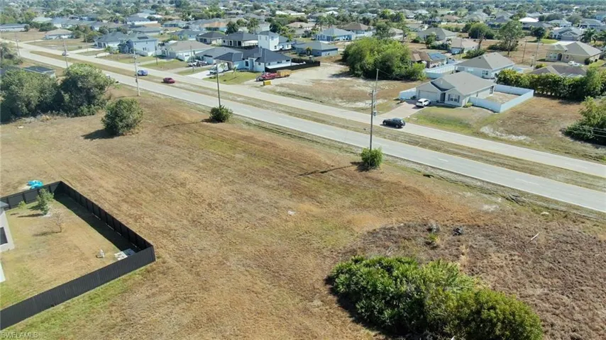 Aerial view of property and surrounding area with nearby suburban area
