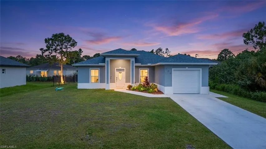 Contemporary exterior with a covered entry, attached garage, concrete driveway, and front landscaping