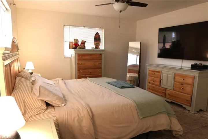 Room featuring a ceiling fan, window with blinds, and light-toned walls
