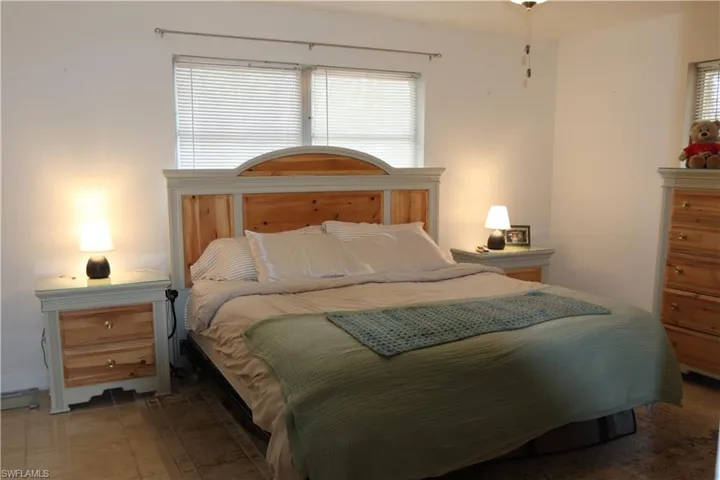 Bedroom featuring a window with horizontal blinds, a ceiling fan, and tile flooring