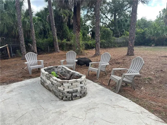Outdoor patio area featuring a concrete pad and a built-in stone planter Wilber won't be there