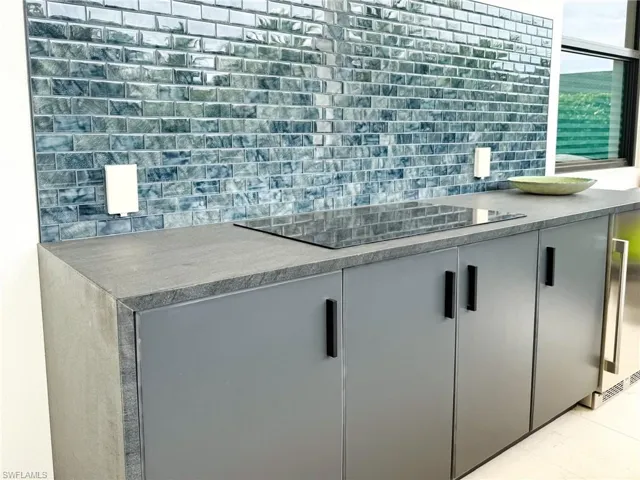 Outdoor Kitchen with Electric Cooktop and Dark Grey Storage Cabinets, Mosaic Tile Backsplash