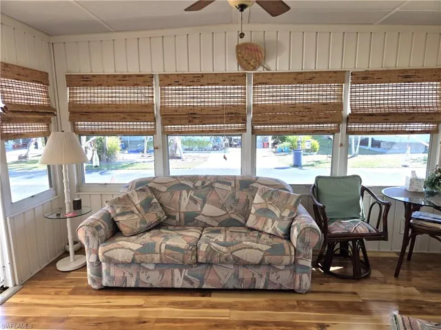 Florida room has beautiful laminate floors and a ceiling fan.