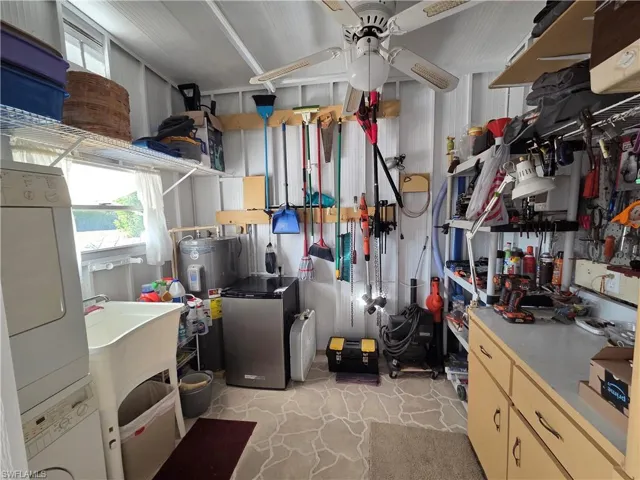 Breezeway laundry room has a ceiling fan, laundry tub, washer, dryer, and storage space. 40 gallon water heater is on a separate electrical panel.