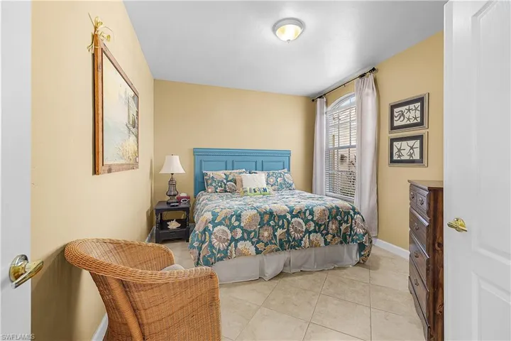 Bedroom featuring light tile patterned floors and baseboards