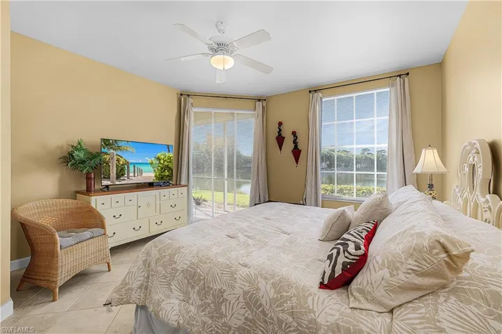 Bedroom featuring access to exterior, light tile patterned floors, and ceiling fan