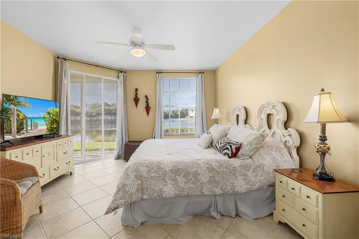 Bedroom with access to exterior, light tile patterned flooring, and ceiling fan