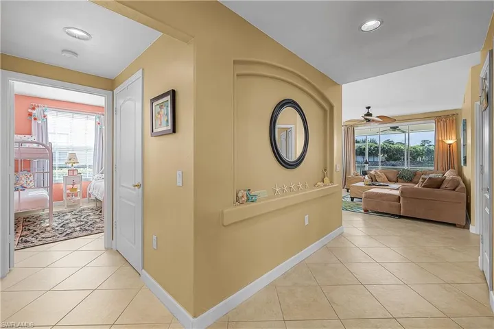 Hallway with light tile patterned floors and recessed lighting