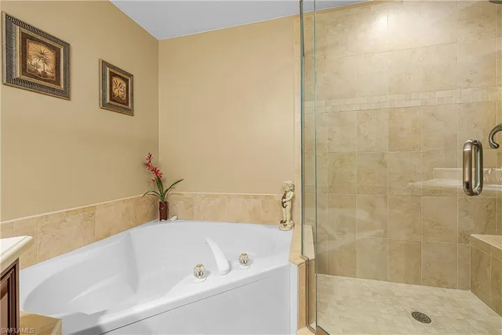 Bathroom featuring a garden tub, vanity, and a stall shower