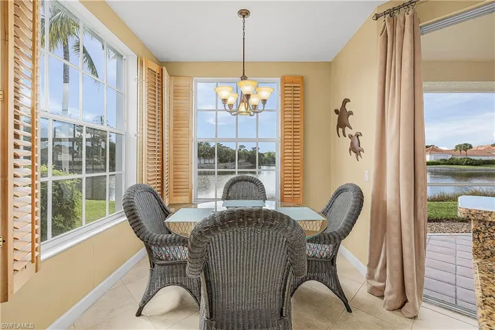 Dining room with a water view, a chandelier, and tile patterned flooring