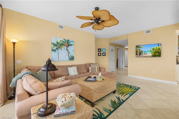 Living area featuring light tile patterned floors and ceiling fan