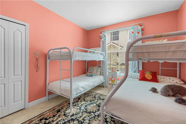 Bedroom featuring light tile patterned floors and a closet