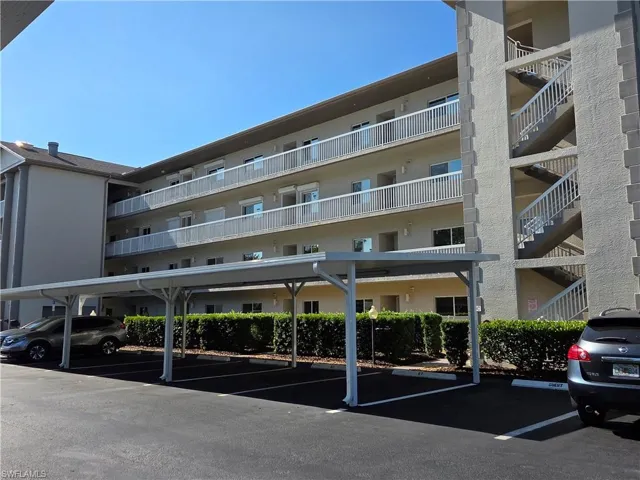 Multi-story residential building featuring exterior stairwells and covered parking