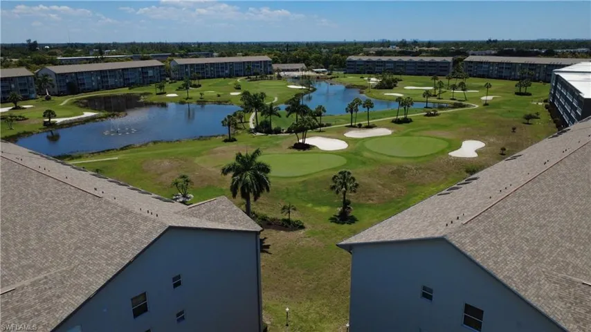 Aerial perspective highlighting a golf course setting with multiple greens, sand traps, and water features