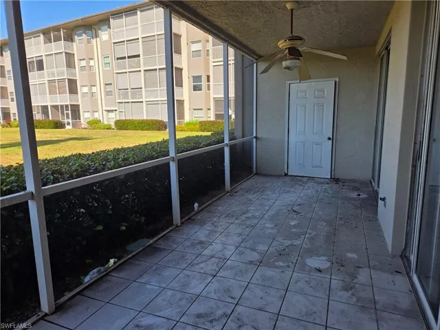 Screened patio featuring tile flooring and a ceiling fan