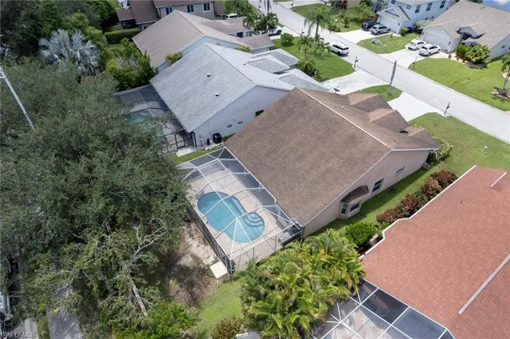 Aerial perspective showcasing a residential property with a screened-in swimming pool
