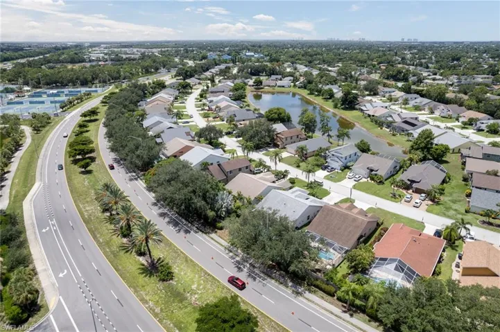 Aerial property overview showcasing a residential district with a central pond