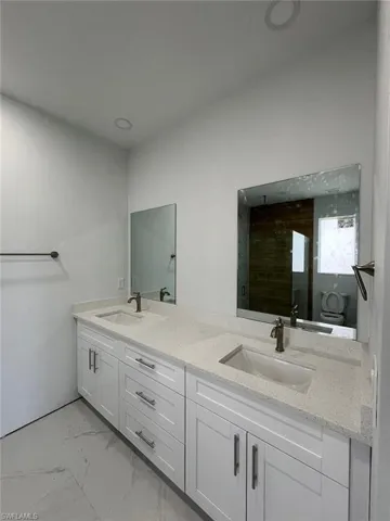 Bathroom featuring tile patterned floors and double sink vanity