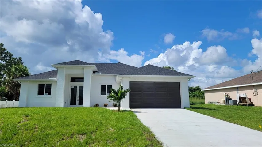 View of front of house with a garage and a front yard