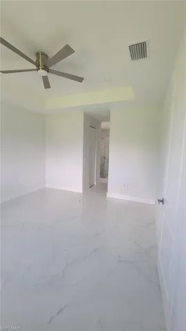 Unfurnished room with light tile patterned flooring and ceiling fan