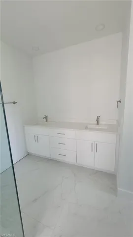 Bathroom with vanity, tile patterned flooring, and a bathing tub