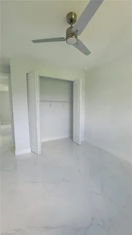 Unfurnished bedroom with a closet, light tile patterned floors, and ceiling fan