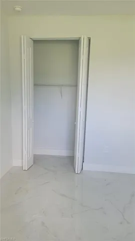 Unfurnished bedroom with light tile patterned flooring and a closet