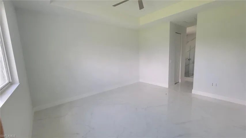 Tiled empty room featuring ceiling fan