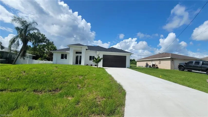 View of front facade featuring a garage and a front yard