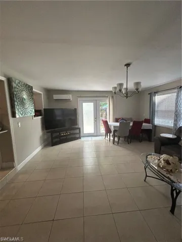 Living room featuring suspended lighting, french doors, and light tile patterned floors