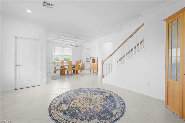 Foyer entrance featuring stairs, crown molding, light tile patterned flooring, recessed lighting, and a ceiling fan