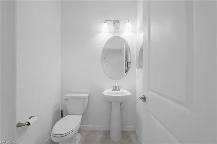 Half bath with toilet and light tile patterned floors