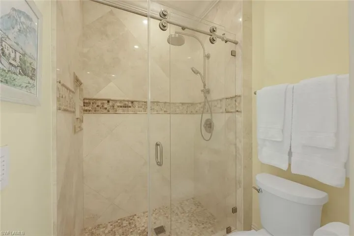Full bath featuring a stall shower and toilet