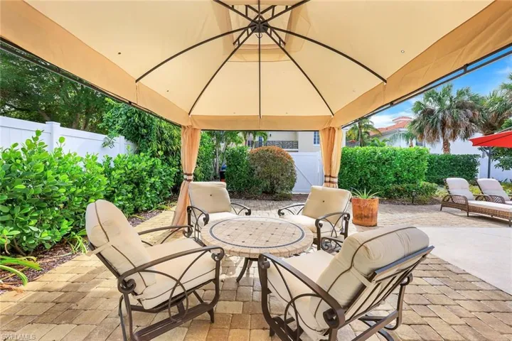 Fenced backyard featuring a patio area and a gazebo