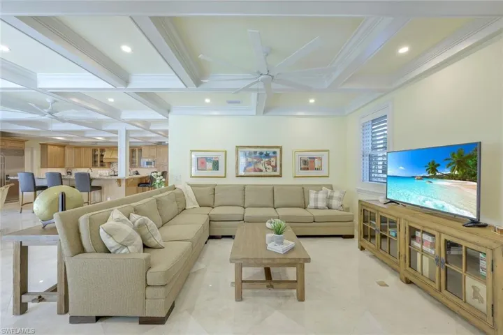 Living room with ceiling fan, beamed ceiling, coffered ceiling, recessed lighting, and ornamental molding