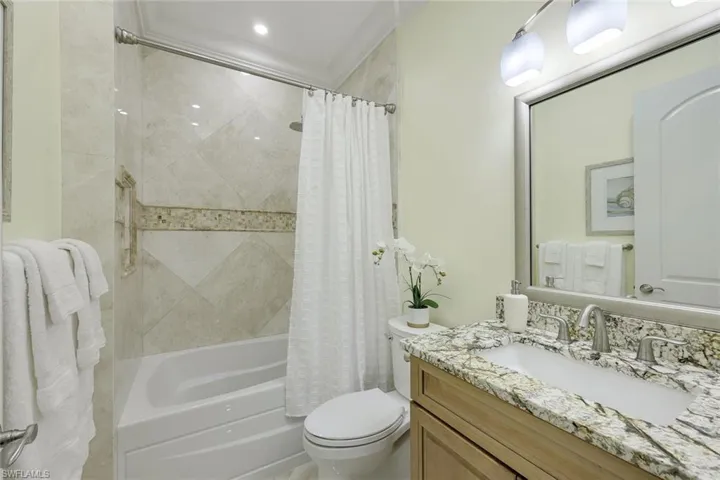 Full bath with shower / bath combination with curtain and vanity