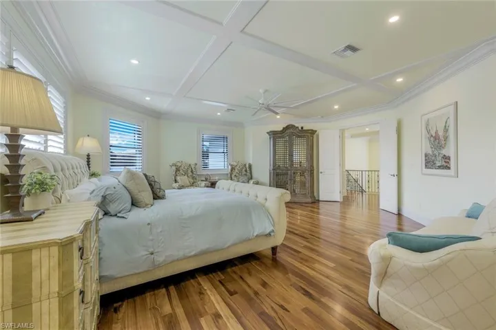 Bedroom featuring ornamental molding, wood finished floors, coffered ceiling, recessed lighting, and beam ceiling