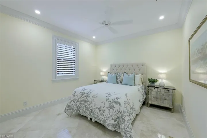 Tiled bedroom with crown molding, a ceiling fan, and recessed lighting